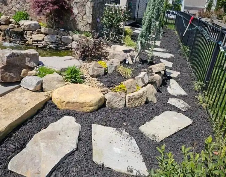 Stone walkway landscape installation with rock garden